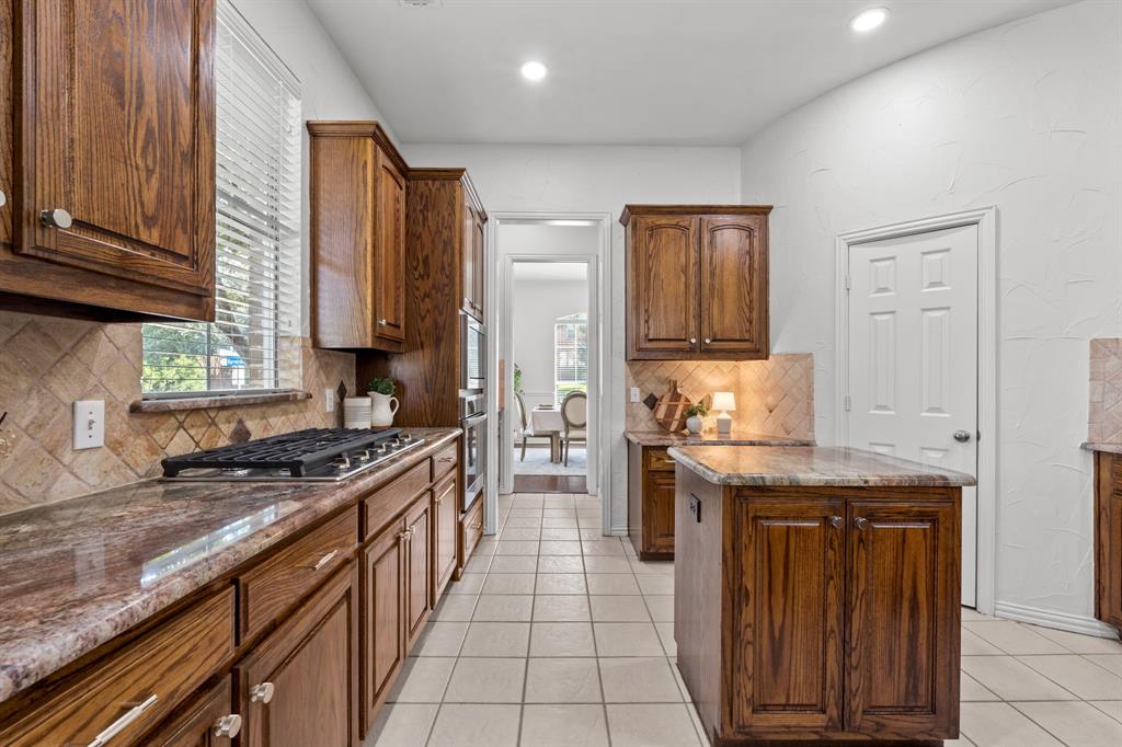 4821 Ravendale Drive Richardson, TX 75082 - Photo 16 of 40 a kitchen with stainless steel appliances granite countertop a stove a sink and a microwave