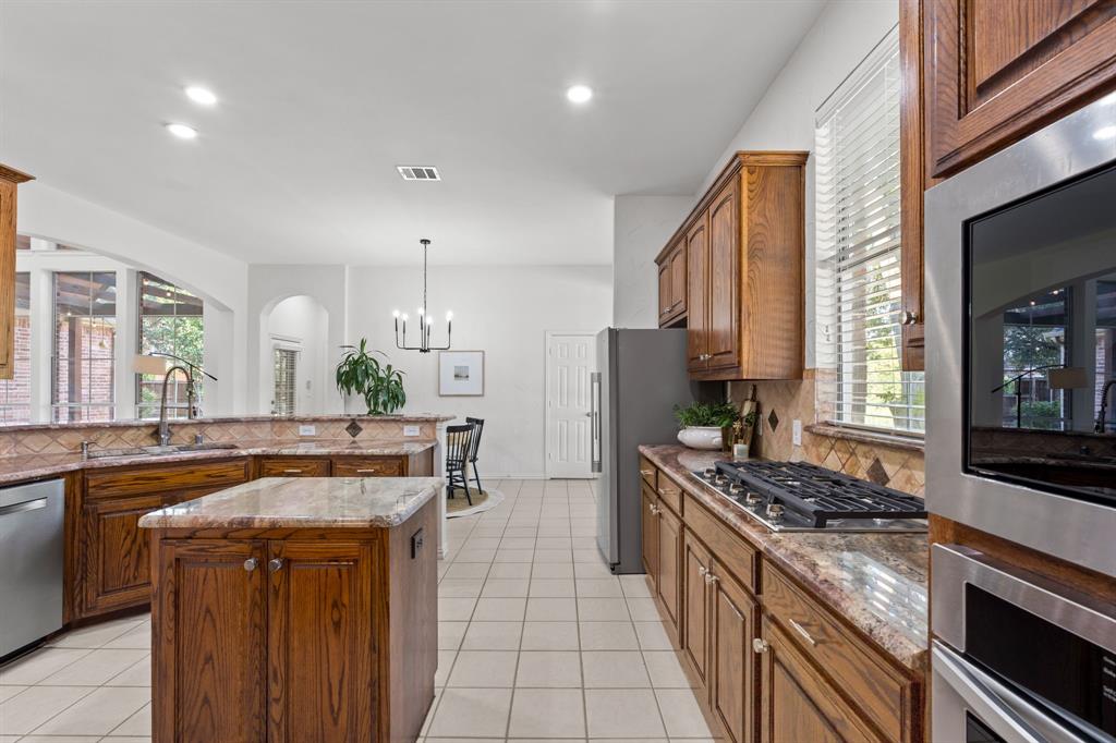 4821 Ravendale Drive Richardson, TX 75082 - Photo 18 of 40 a kitchen with stainless steel appliances a sink and a stove