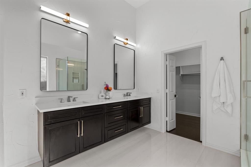 4821 Ravendale Drive Richardson, TX 75082 - Photo 26 of 40 a bathroom with a double vanity sink and a mirror