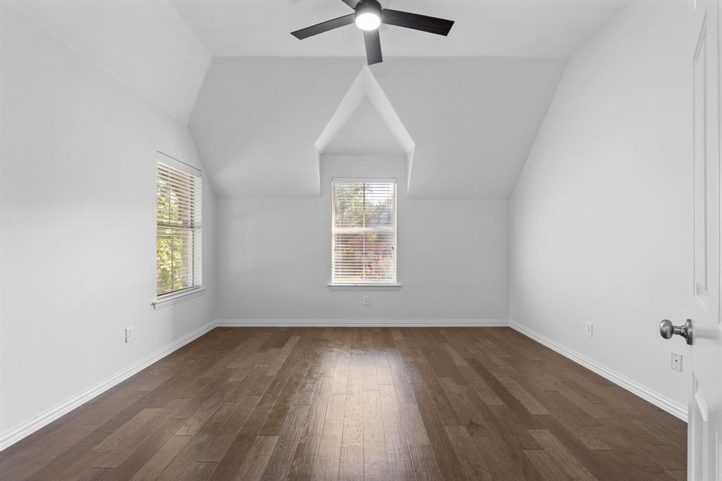 4821 Ravendale Drive Richardson, TX 75082 - Photo 31 of 40 an empty room with wooden floor chandelier fan and windows
