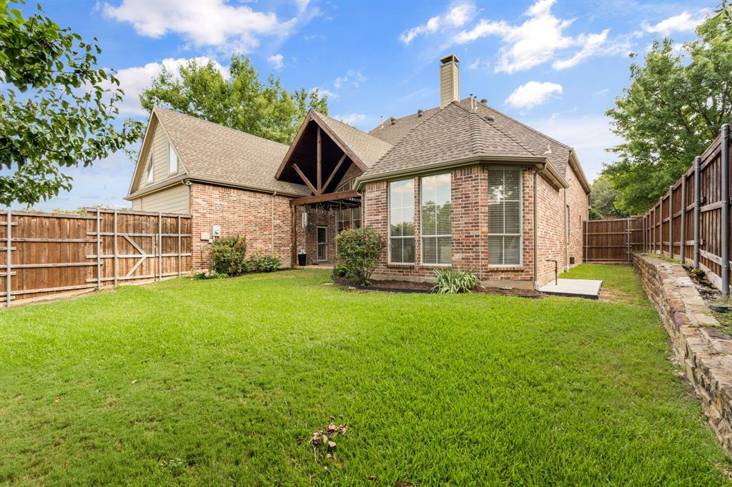 4821 Ravendale Drive Richardson, TX 75082 - Photo 37 of 40 a front view of a house with a garden and yard