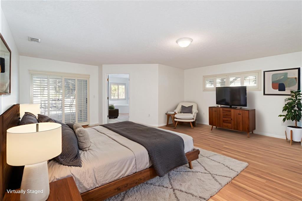 729 Strihal Loop Oakland, FL 34787 - Photo 13 of 33 a spacious bedroom with a bed a couch and large windows