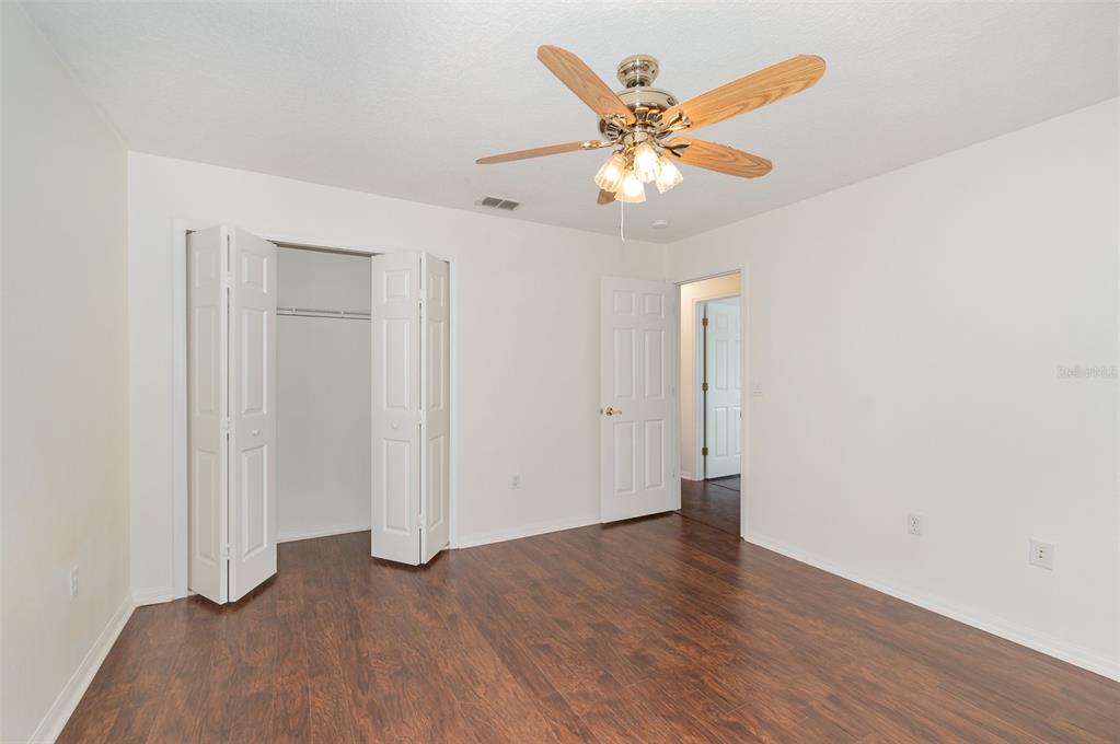 729 Strihal Loop Oakland, FL 34787 - Photo 24 of 33 an empty room with wooden floor fan and windows