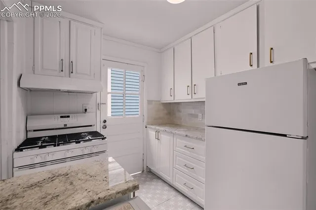 a kitchen with white cabinets and white appliances