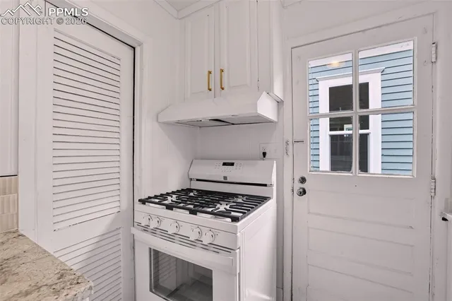 a kitchen with a stove and a window