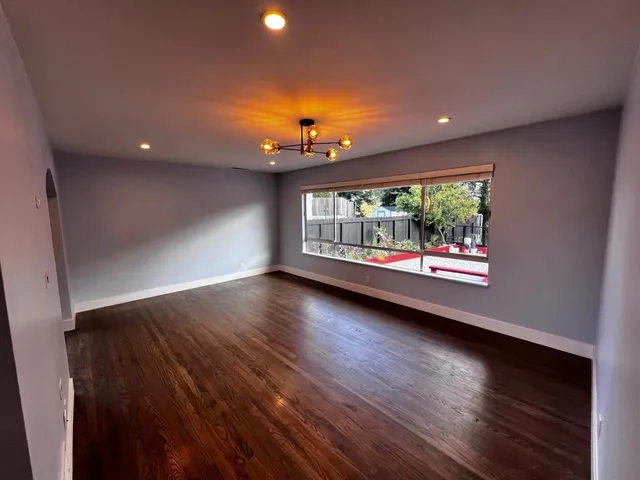 wooden floor in an empty room with a window