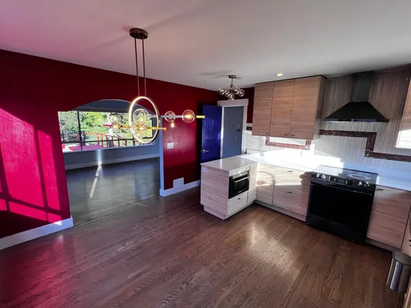 a kitchen with granite countertop wooden cabinets and a stove