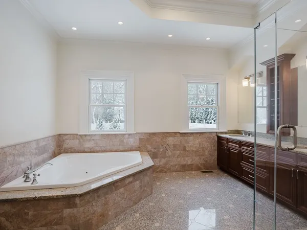 a bathroom with a granite countertop tub a sink and a window