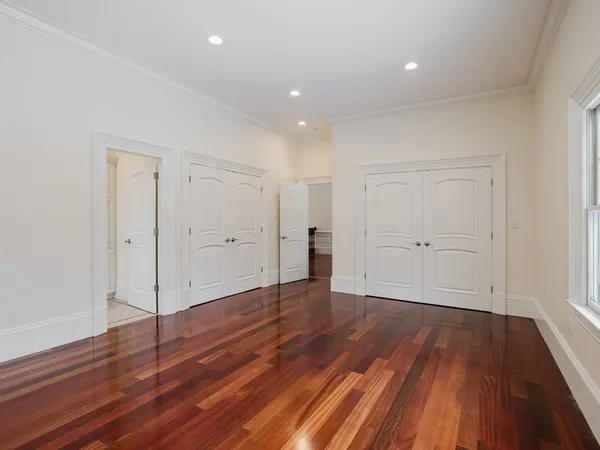 a view of an empty room with wooden floor