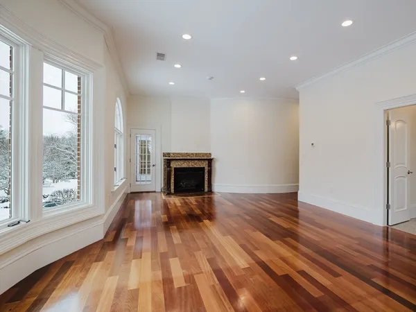 a view of empty room with wooden floor and fireplace