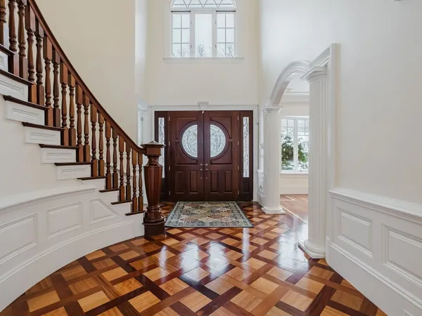 a view of a hallway with wooden floor and staircase