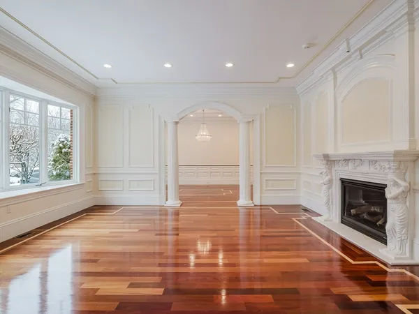 a view of empty room with wooden floor and fireplace
