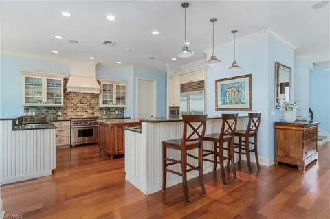 a kitchen with stainless steel appliances granite countertop wooden floor window and cabinets