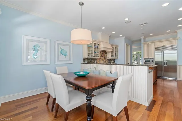 a view of a dining room with furniture a chandelier and wooden floor