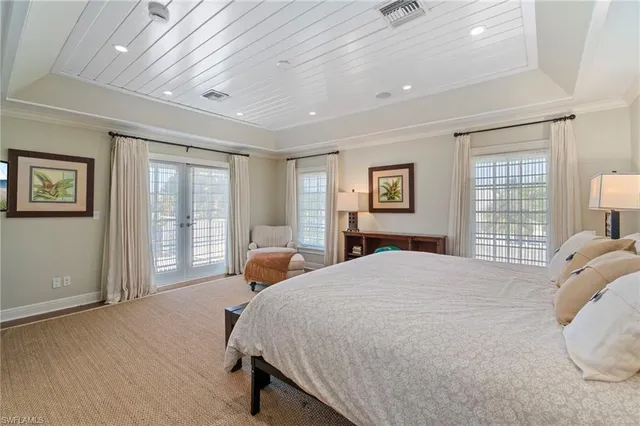 a bedroom with a large bed and wooden floor