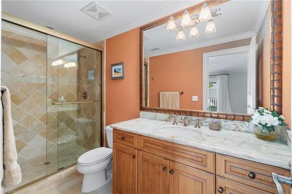 a bathroom with a granite countertop sink a toilet and shower