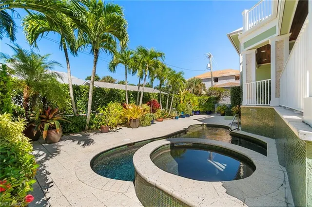 a house view with a swimming pool and sitting area