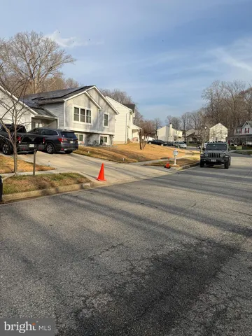 a view of residential houses with cars parked on road