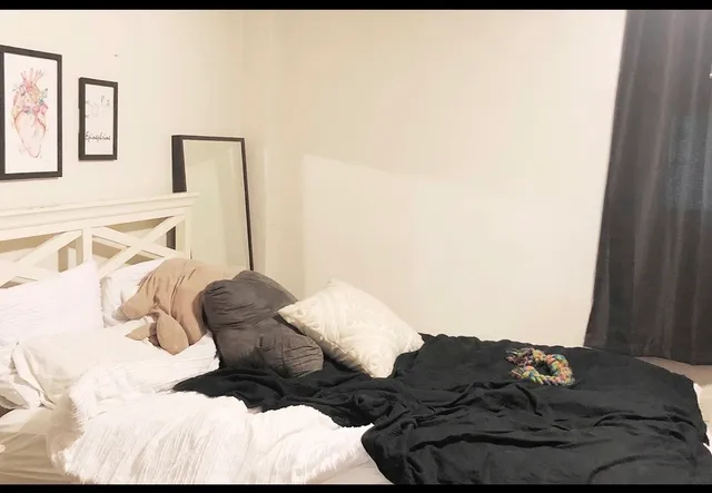 a bed with white sheets and pillows on it