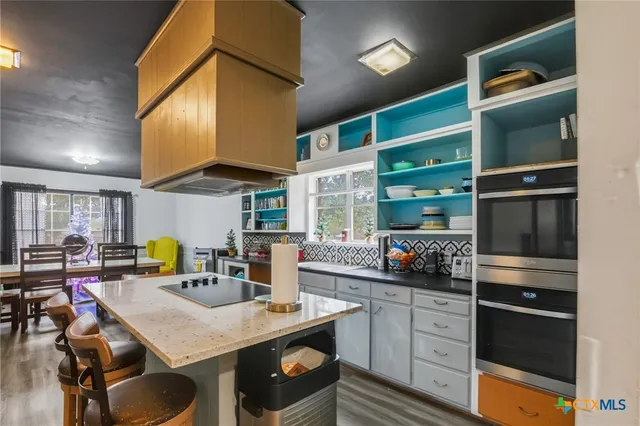 a kitchen with a refrigerator and chairs
