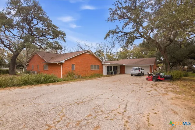 a view of a house with a yard and large tree