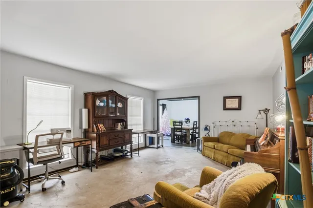 a living room with furniture a flat screen tv and a window