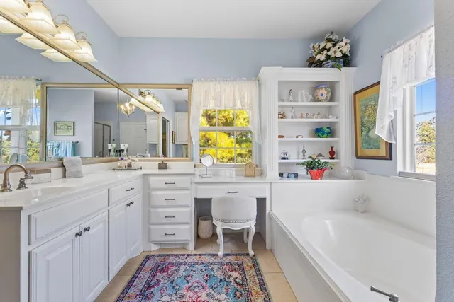 a spacious bathroom with a granite countertop tub sink and mirror