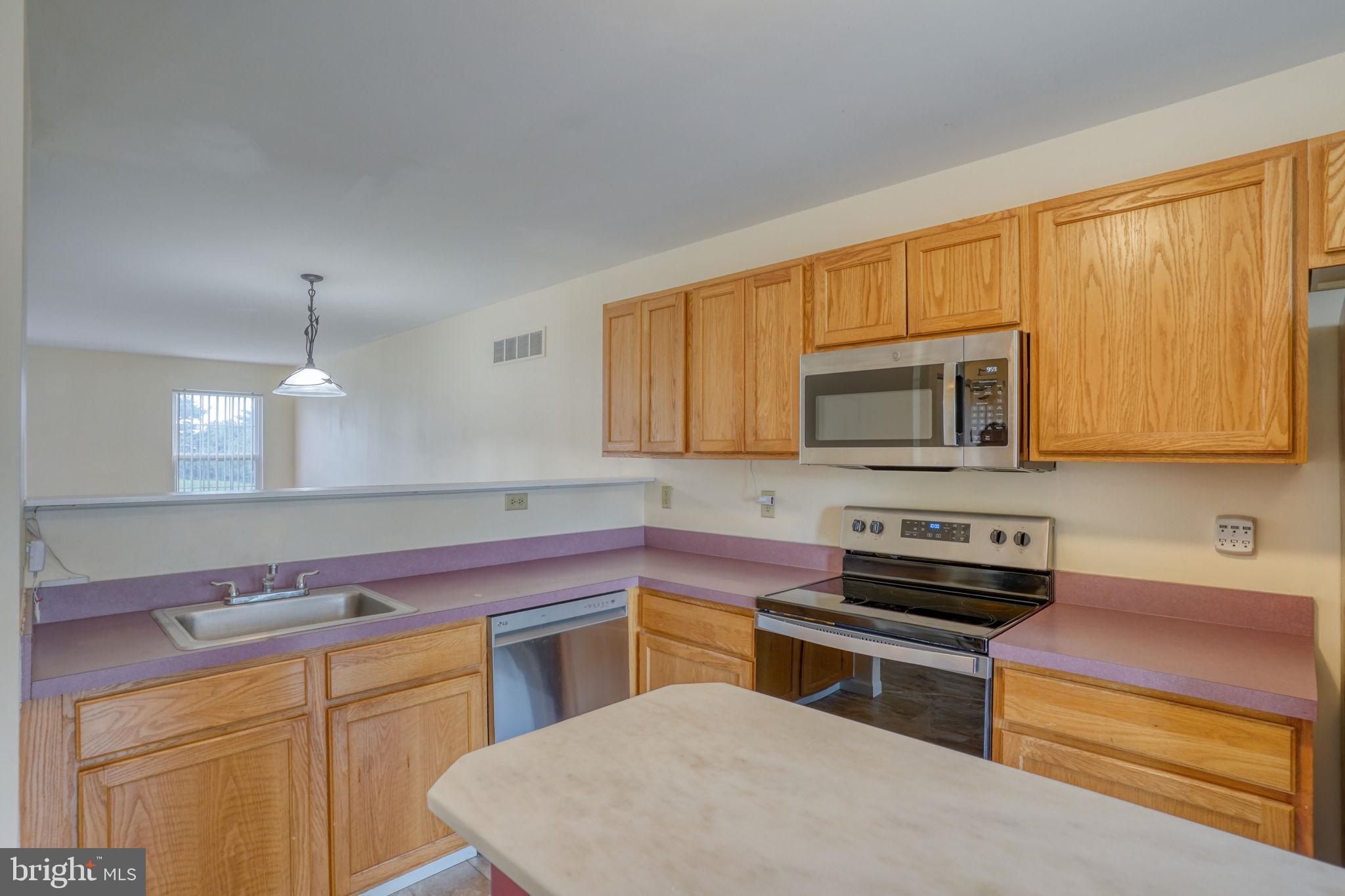 197 Bonnybrook Road Middletown, DE 19709 - Photo 6 of 32 a kitchen with stainless steel appliances a stove a sink cabinets and a microwave