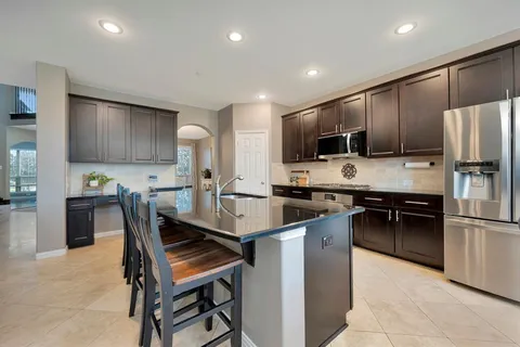 a kitchen with kitchen island a refrigerator stove microwave and cabinets