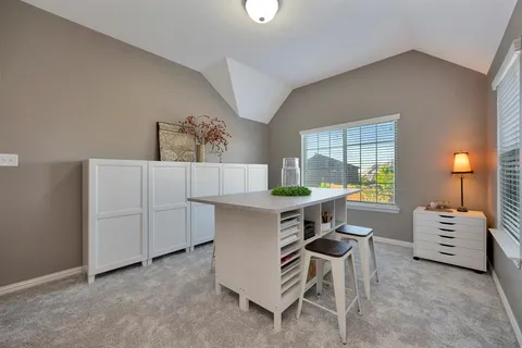 a view of a workspace with furniture and a window