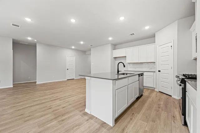 a view of empty room with wooden floor and windows