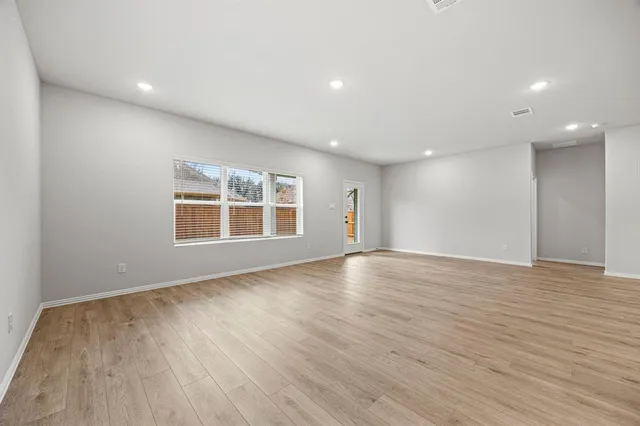 a view of kitchen with kitchen island wooden floor center island and stainless steel appliances