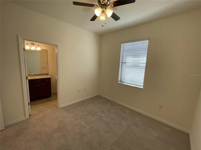 an empty room with windows and cabinet