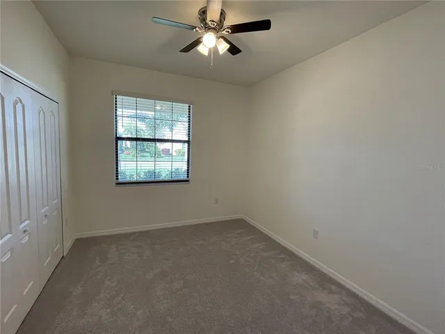 a view of a room with a ceiling fan and a window