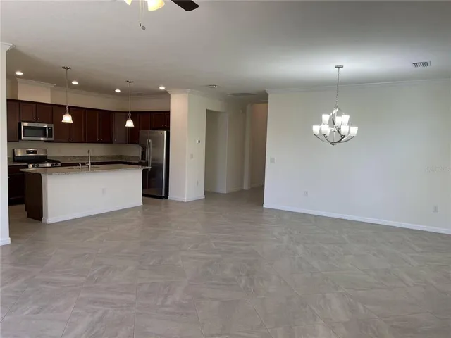 an empty room with a window and a ceiling fan