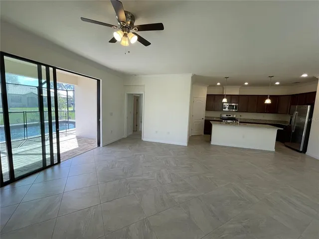 an empty room with fan and windows