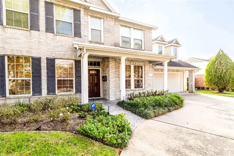 front view of a brick house with a yard