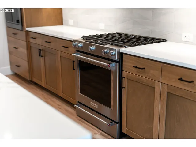 a kitchen with granite countertop a stove and a microwave