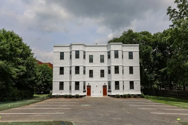 a front view of a building with a garden