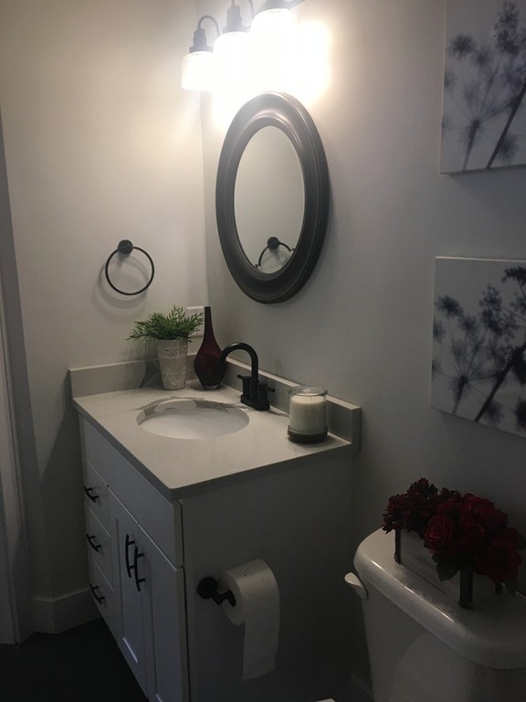 45 Clement Avenue, Unit 3 Boston, MA 02132 - Photo 20 of 35 a bathroom with a toilet sink vanity and mirror