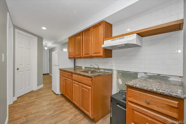a kitchen with stainless steel appliances granite countertop wooden cabinets and a stove top oven