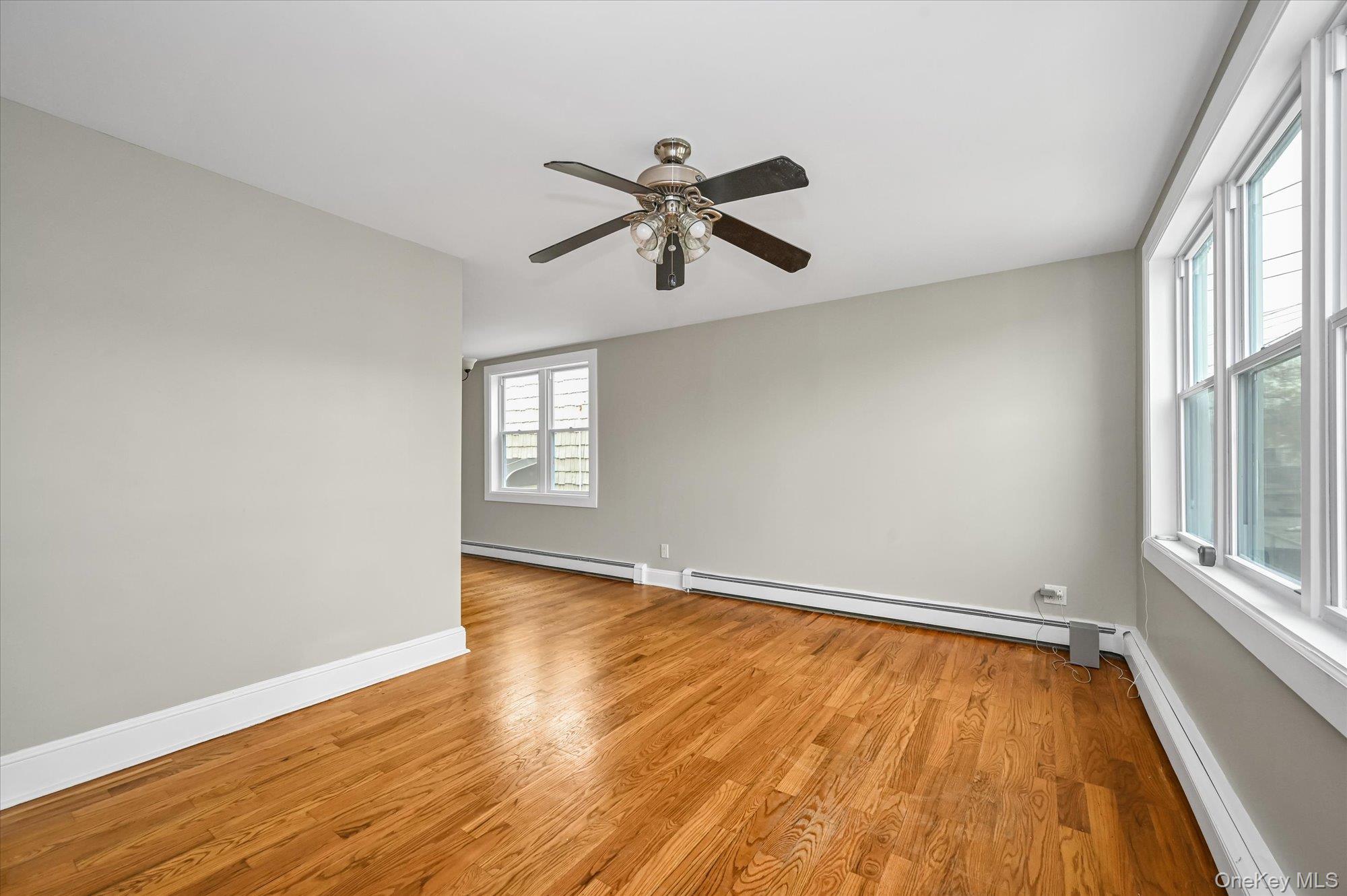 64-39 58th Road Queens, NY 11378 - Photo 2 of 19 an empty room with wooden floor and windows