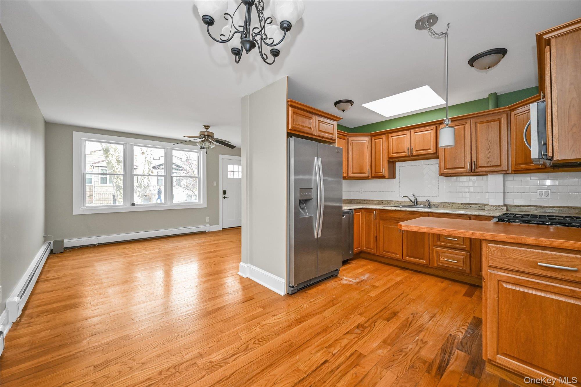 64-39 58th Road Queens, NY 11378 - Photo 4 of 19 a kitchen with stainless steel appliances granite countertop a refrigerator a sink dishwasher a stove and white countertops with wooden floor