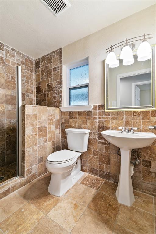 909 North Dove Road Grapevine, TX 76051 - Photo 23 of 30 2nd full Bathroom featuring a pedestal sink, a toilet, and a walk-in shower with glass enclosure