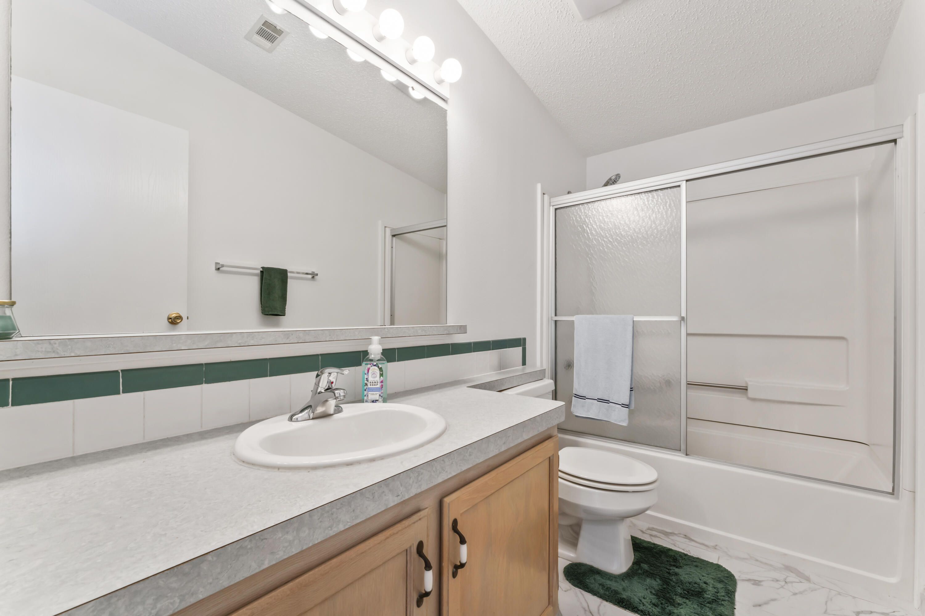 8913 Southwest Chevy Circle Stuart, FL 34997 - Photo 16 of 22 a bathroom with a granite countertop sink toilet a mirror and shower