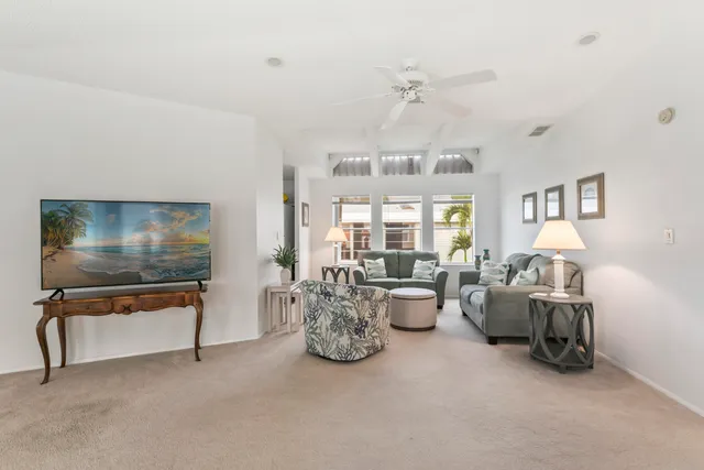 a living room with furniture a chandelier and a flat screen tv