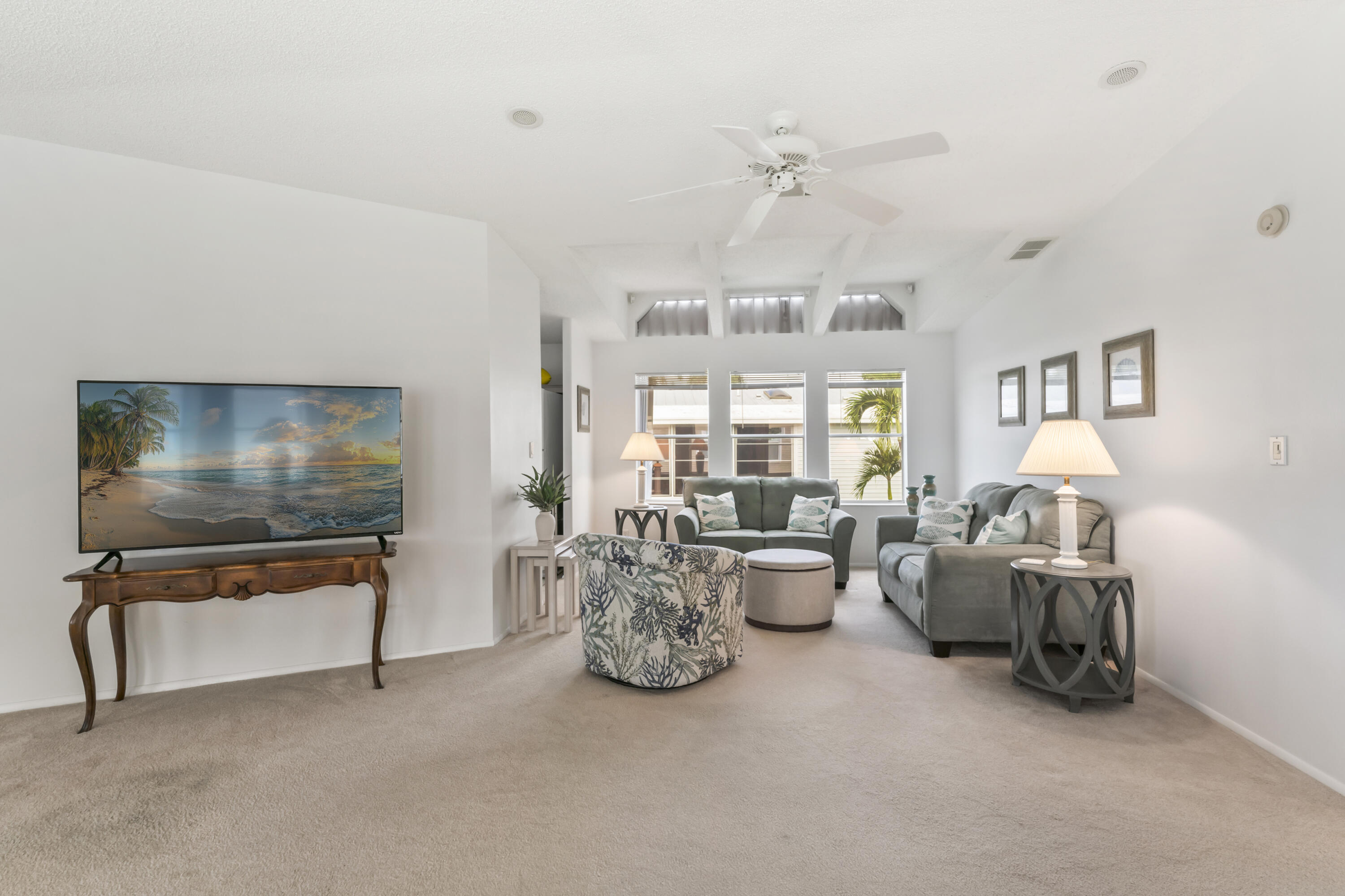 8913 Southwest Chevy Circle Stuart, FL 34997 - Photo 6 of 22 a living room with furniture a chandelier and a flat screen tv