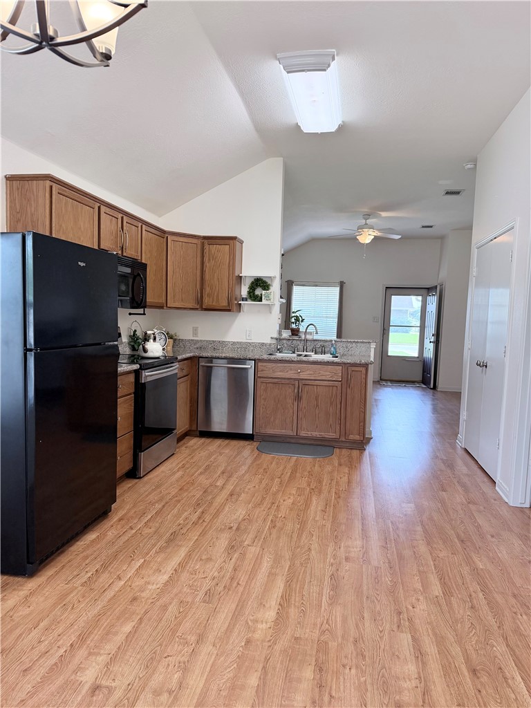 1029 Fallbrook Loop College Station, TX 77845 - Photo 11 of 34 a kitchen with stainless steel appliances granite countertop a refrigerator oven a sink dishwasher and wooden floor