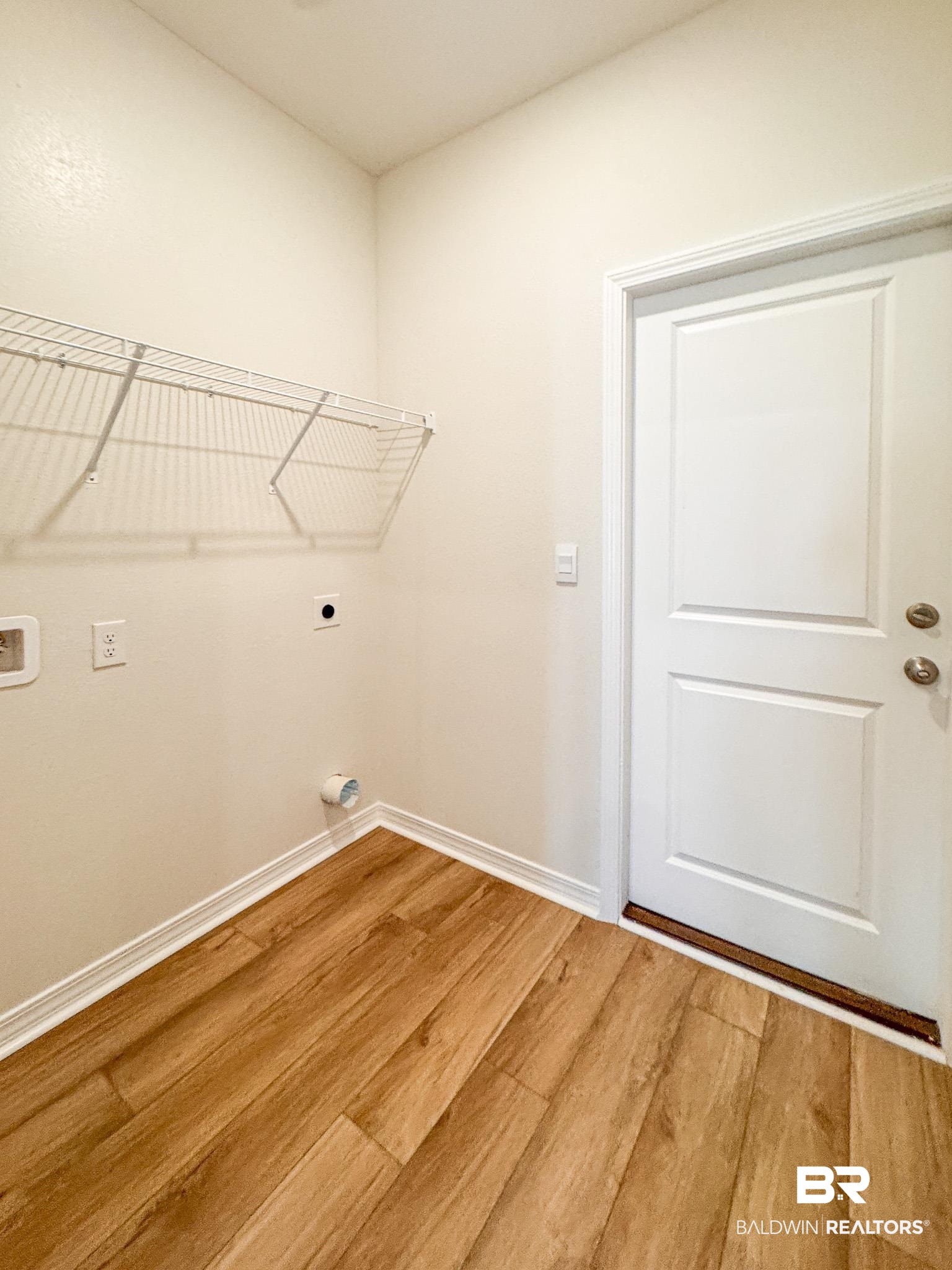 18151 Kent Circle Foley, AL 36535 - Photo 13 of 25 Dedicated laundry space featuring wood-finish flooring, light-toned walls, and a white wire shelf
