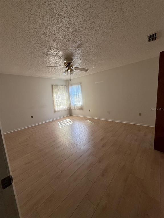 9706 Southwest 30th Terrace Ocala, FL 34476 - Photo 5 of 16 en empty room with windows and chandelier fan